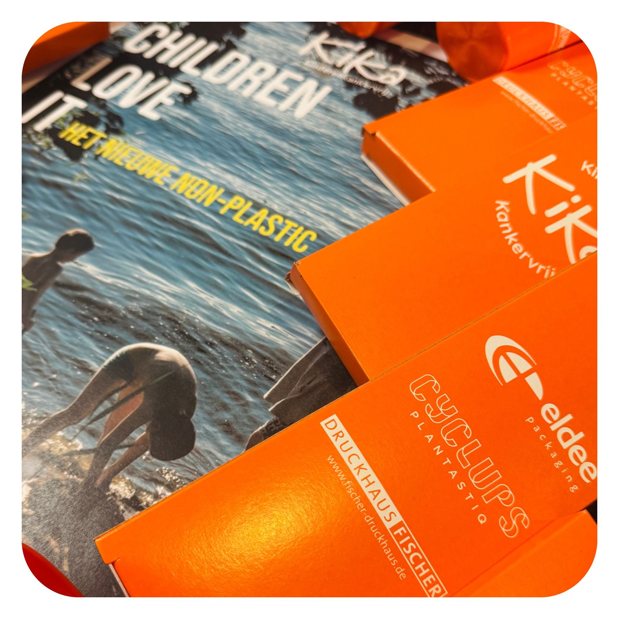 Cyclups Plantastiq 'Children Love It: The New Non-Plastic' campaign - orange packaging boxes with KiKa Kankervrij charity partnership branding