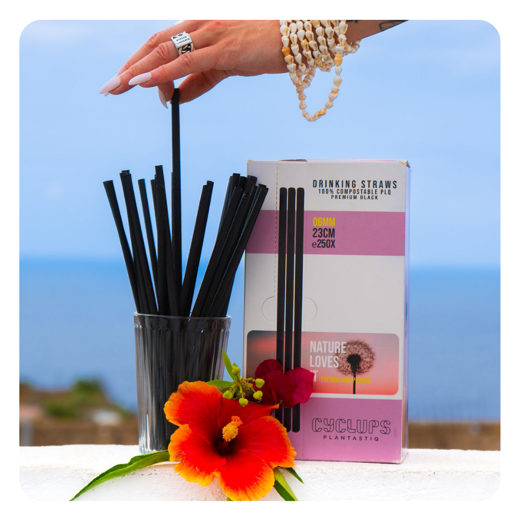 Black compostable PLQ drinking straws 08mm made from wheat, in a glass with tropical flowers - Cyclups Plantastiq